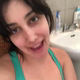 A very cute girl bends over a toilet from a rear view as she shits, followed by a look at the product in a green toilet bowl. Vertical format video. Over 2 minutes.